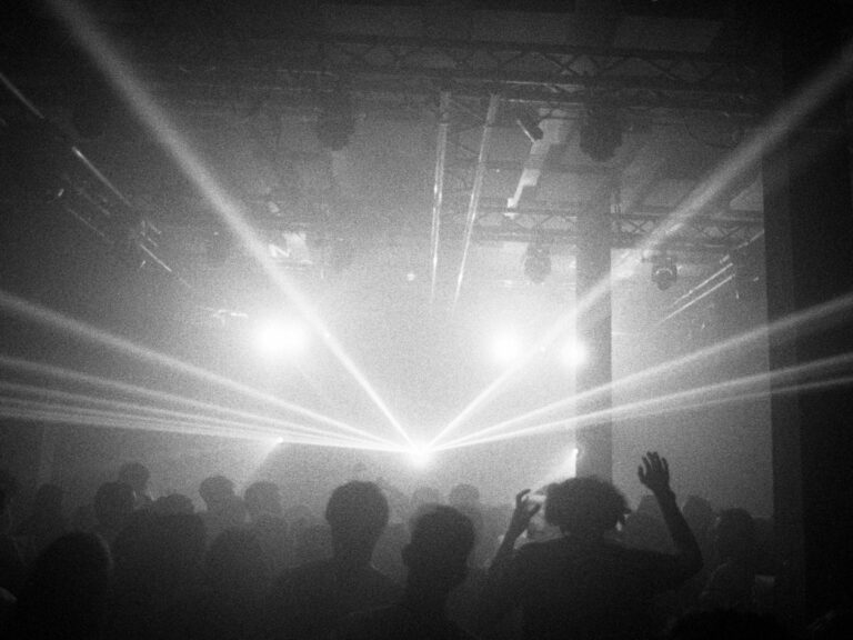 Photo argentique d'une soirée en club techno avec rayons lumineux et foule
